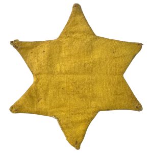 Worn yellow Star of David badge made of coarse fabric, used in Hungary during the Holocaust to identify Jewish people under Nazi persecution.